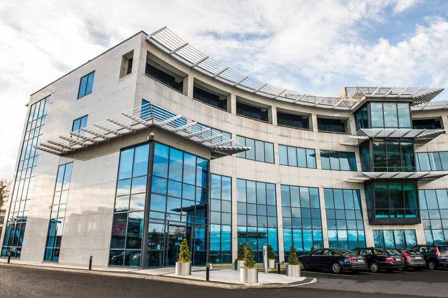 Modern glass office building exterior against a blue sky