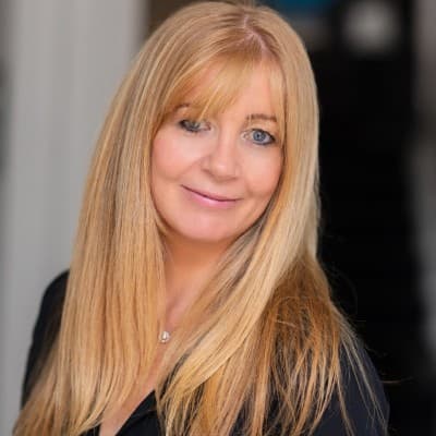 Headshot of Jane, Capitalflow team member, smiling against a dark background