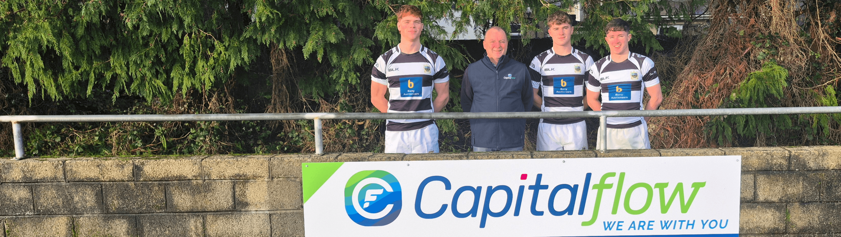 three people in striped rugby jerseys outdoors with trees behind, Capitalflow watermark visible