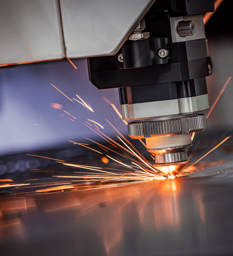 CNC laser cutter cutting metal with sparks flying, close-up industrial shot