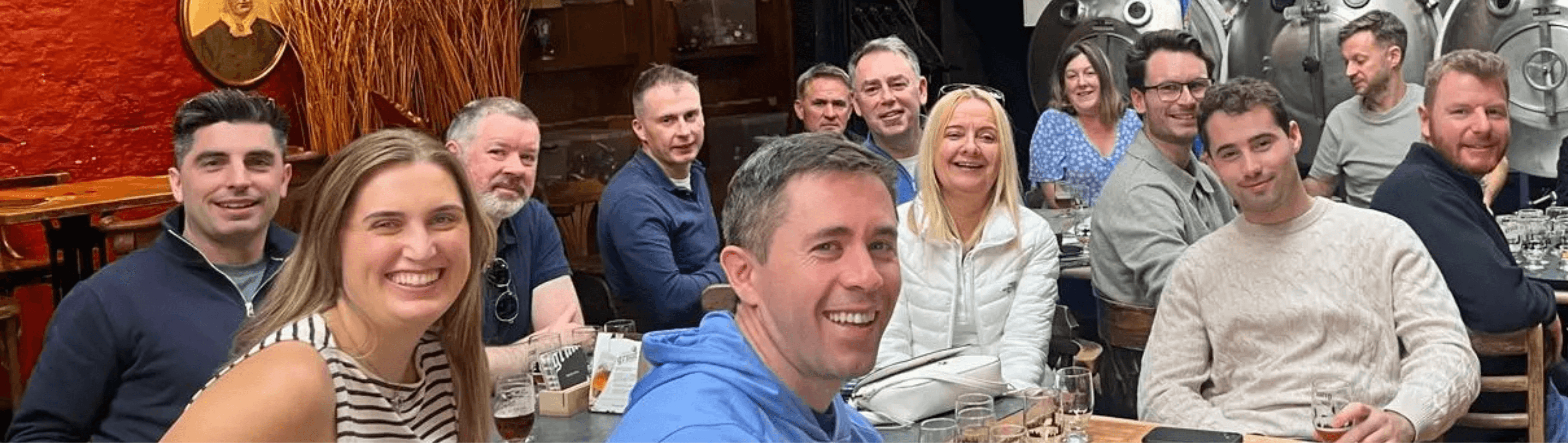 Group of people gathered indoors at a bar or pub, casual social setting