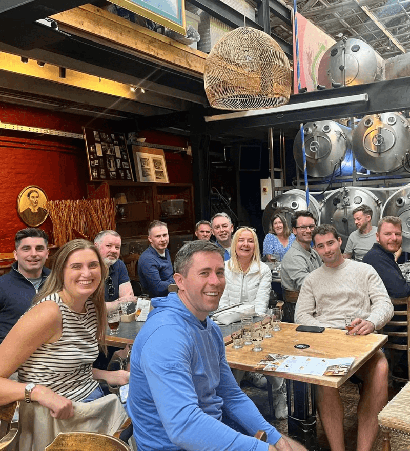 Group of people gathered indoors at a bar or pub, casual social setting