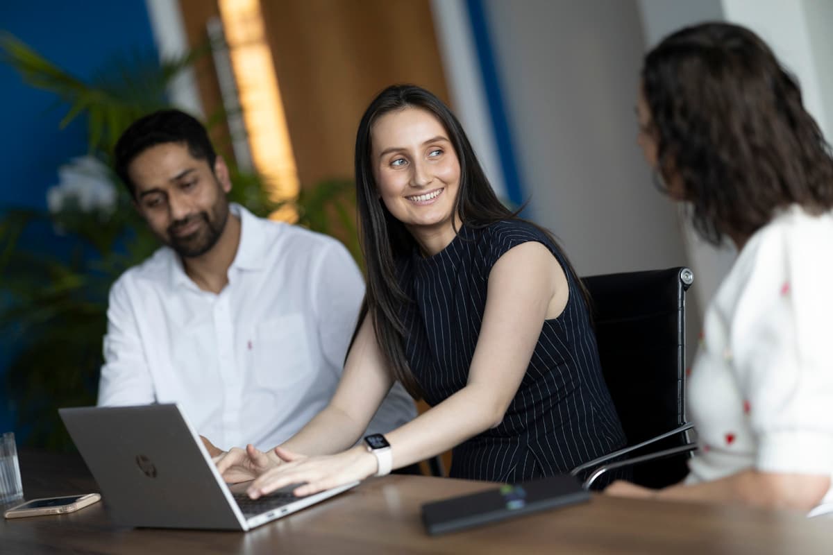 Man and woman seated together indoors, smiling, casual office setting