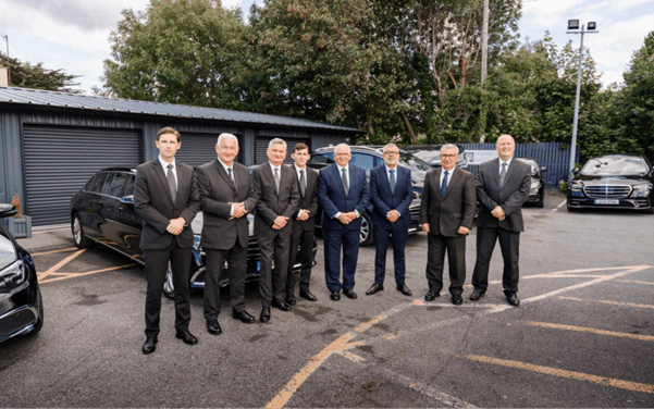 Group of men in dark suits standing together outdoors