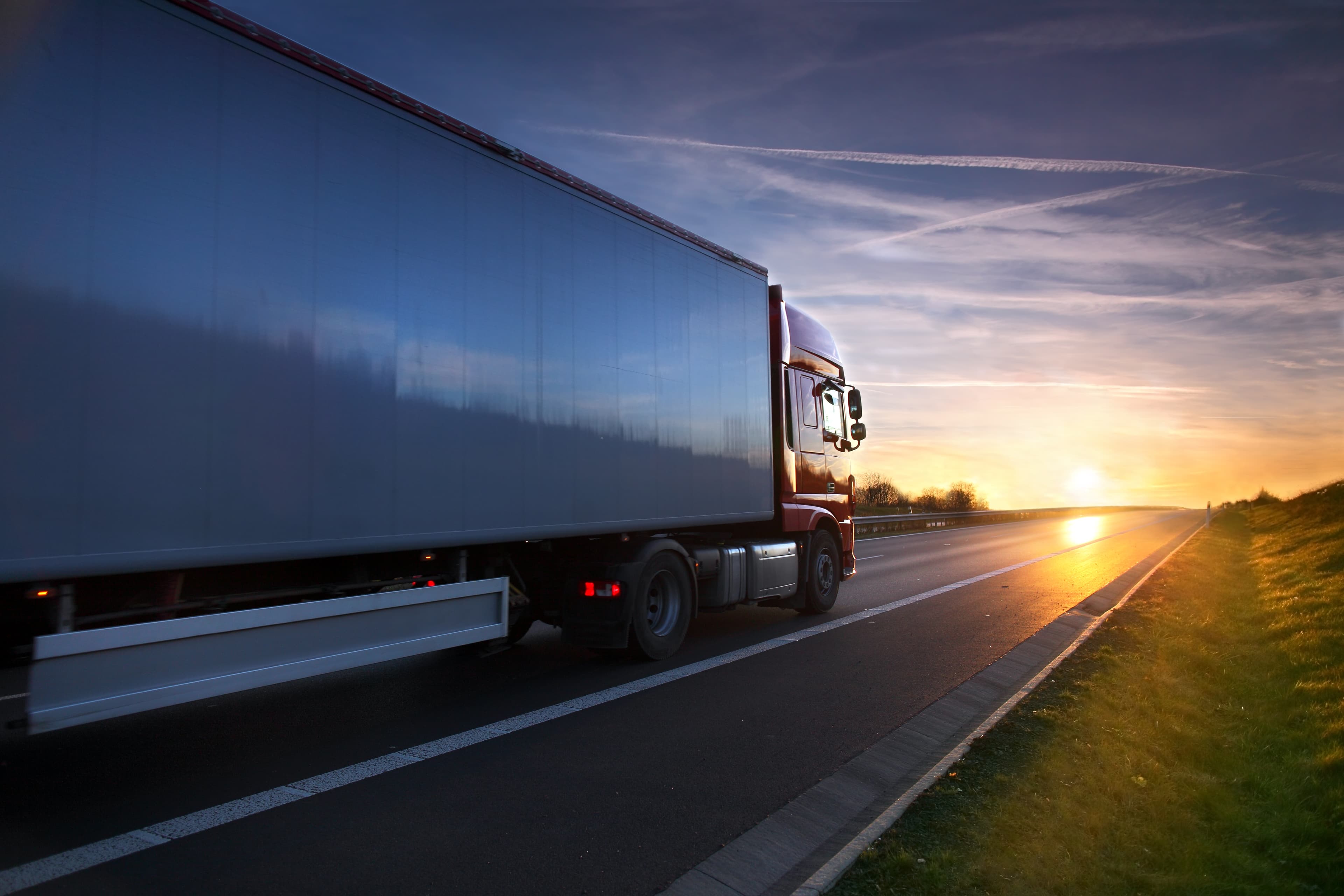 Lorry/truck driving on a road at sunset, motion blur