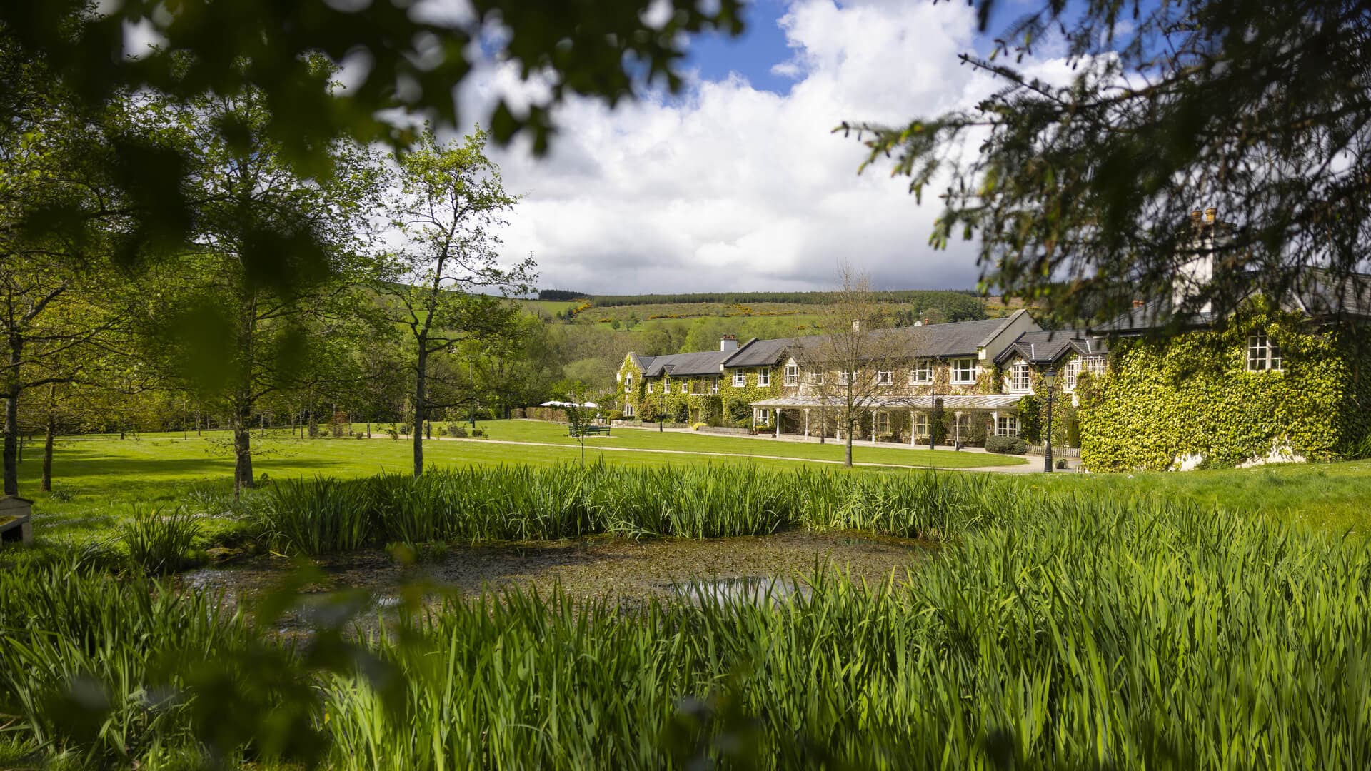 Exterior of a hotel/venue building with trees and manicured lawn