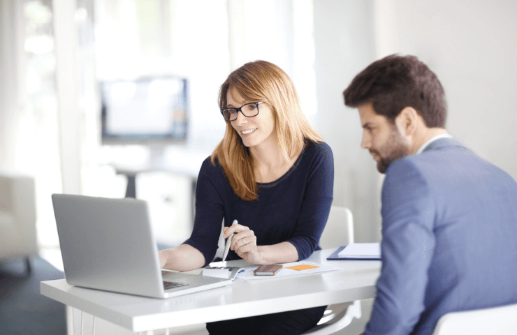 Man and woman shown working together at a laptop